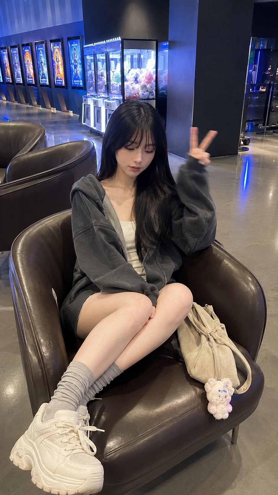 A young East Asian woman in her early 20s sits diagonally in a dark bro…