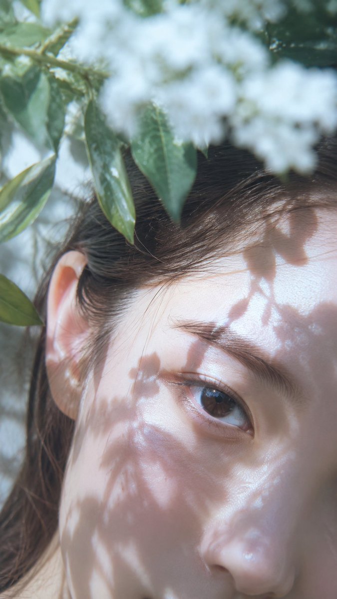 日系清新自然光人像特写，竖幅极近距离构图，女性面部斜向贴近镜头，只突出一只清澈湿润的眼睛、眉骨、额头、耳部和少量发丝，身体不入画；冷白到象牙白…