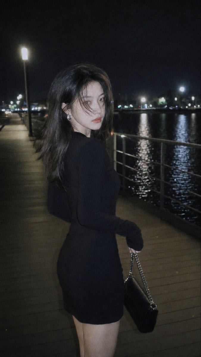摄影风格：柔光CCD风 写真方向：夜色都市氛围街拍 场景方向：湖边夜间栈道 / 路灯 / 水面倒影 / 栏杆步道 服装方向：黑色长袖修身连衣裙…