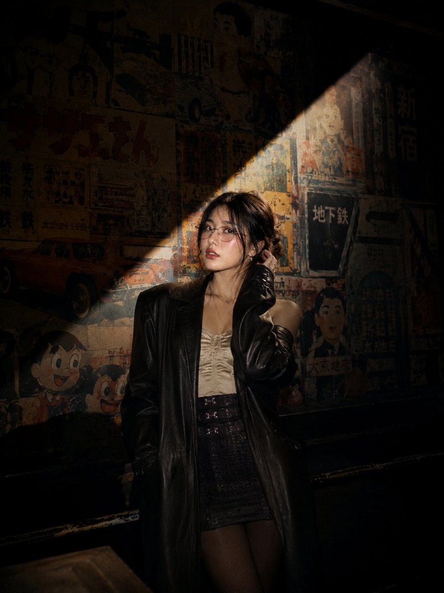 Cinematic nighttime portrait of a stylish young Asian woman standing on…