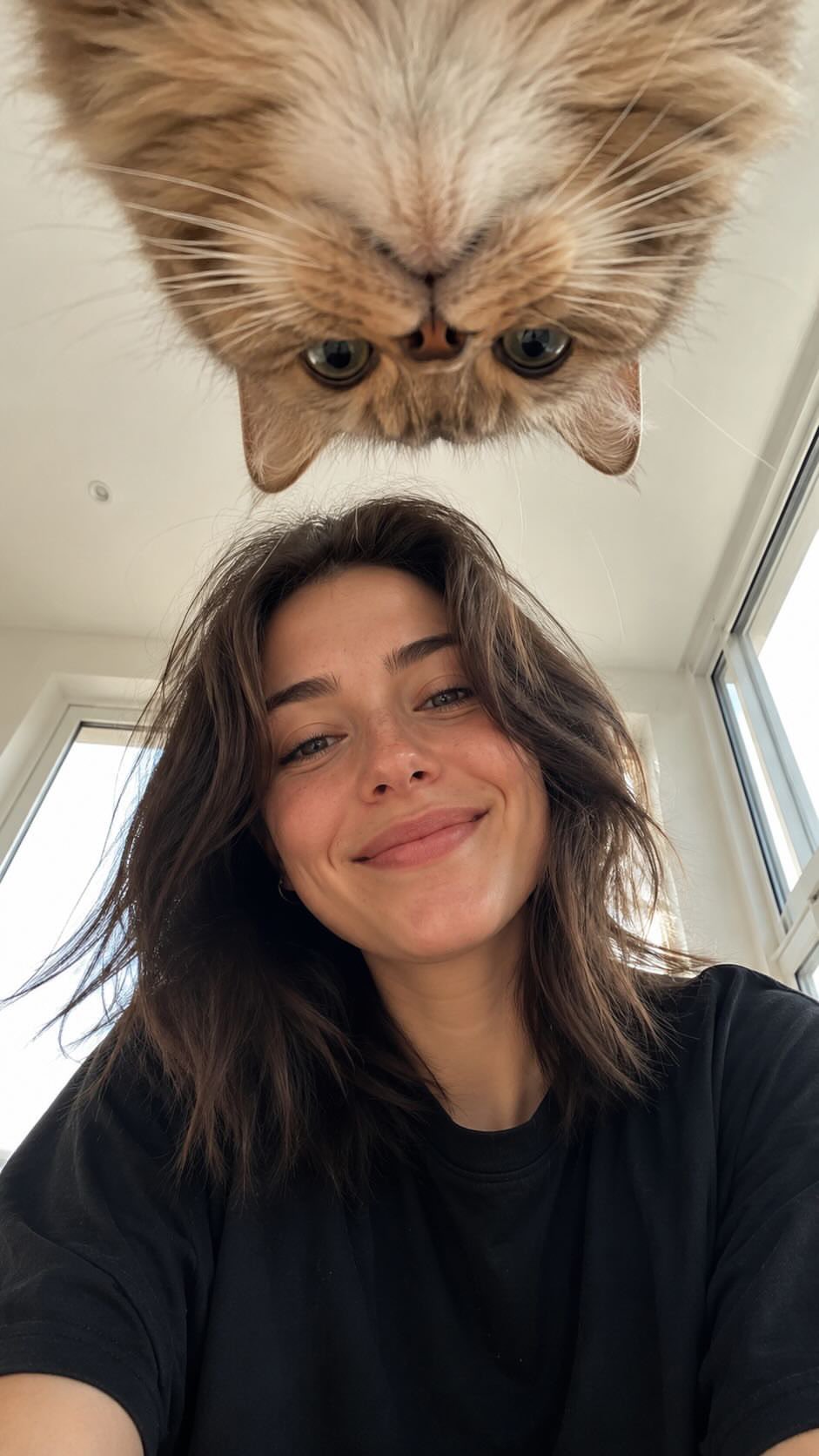 Create a realistic vertical smartphone selfie taken indoors from a very…