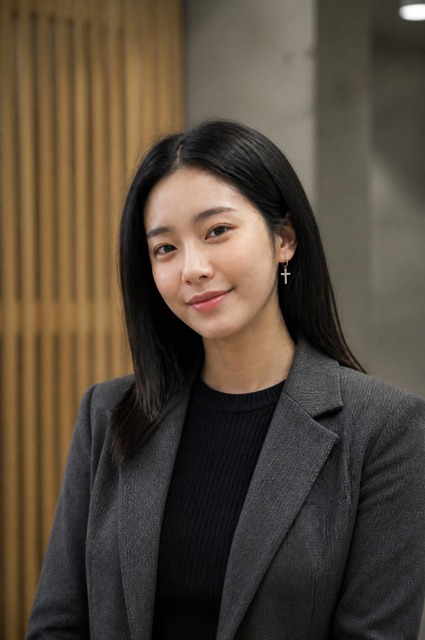 A young East Asian woman with shoulder-length dark hair stands in a pro…