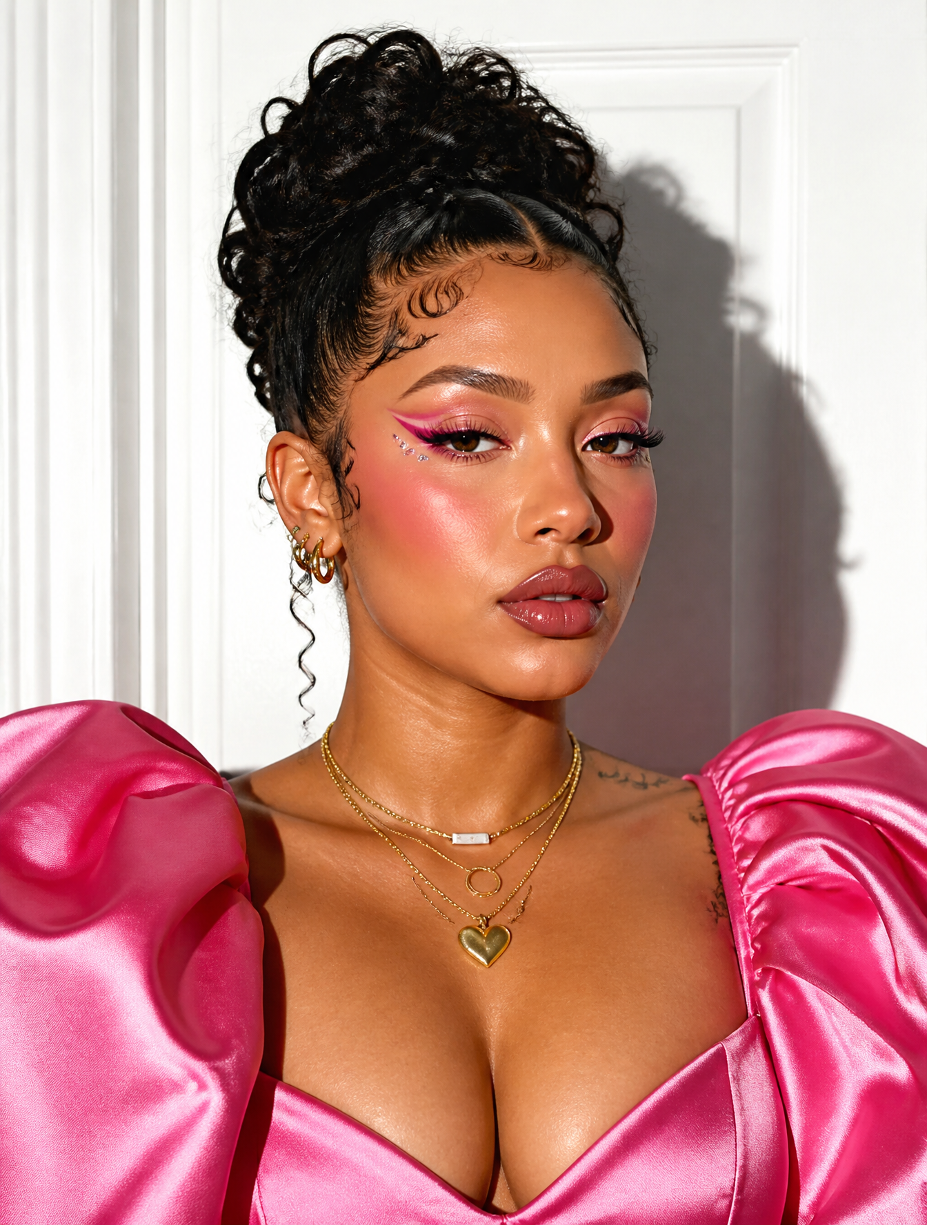 A portrait of a woman with an intricate updo and styled baby hairs feat…