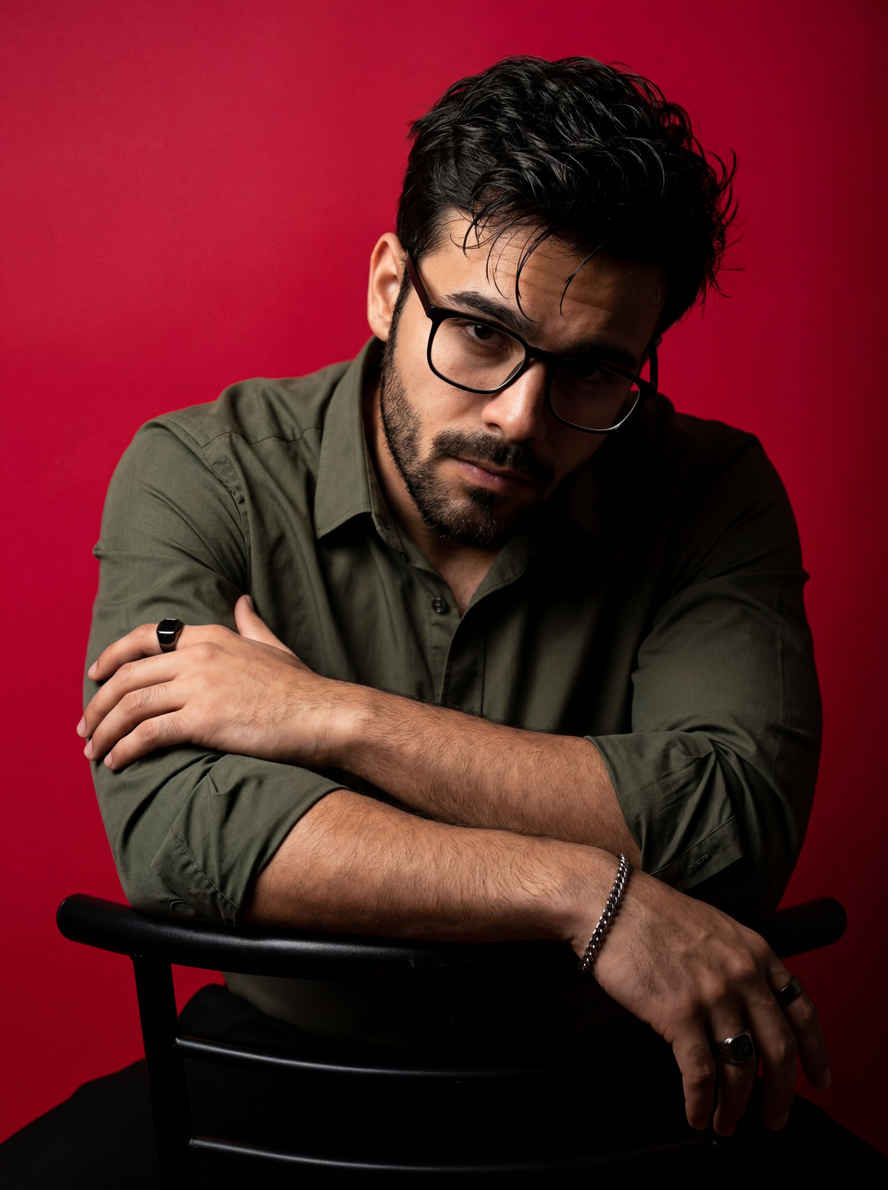 A dramatic, high-contrast studio portrait of a man with dark messy hair…