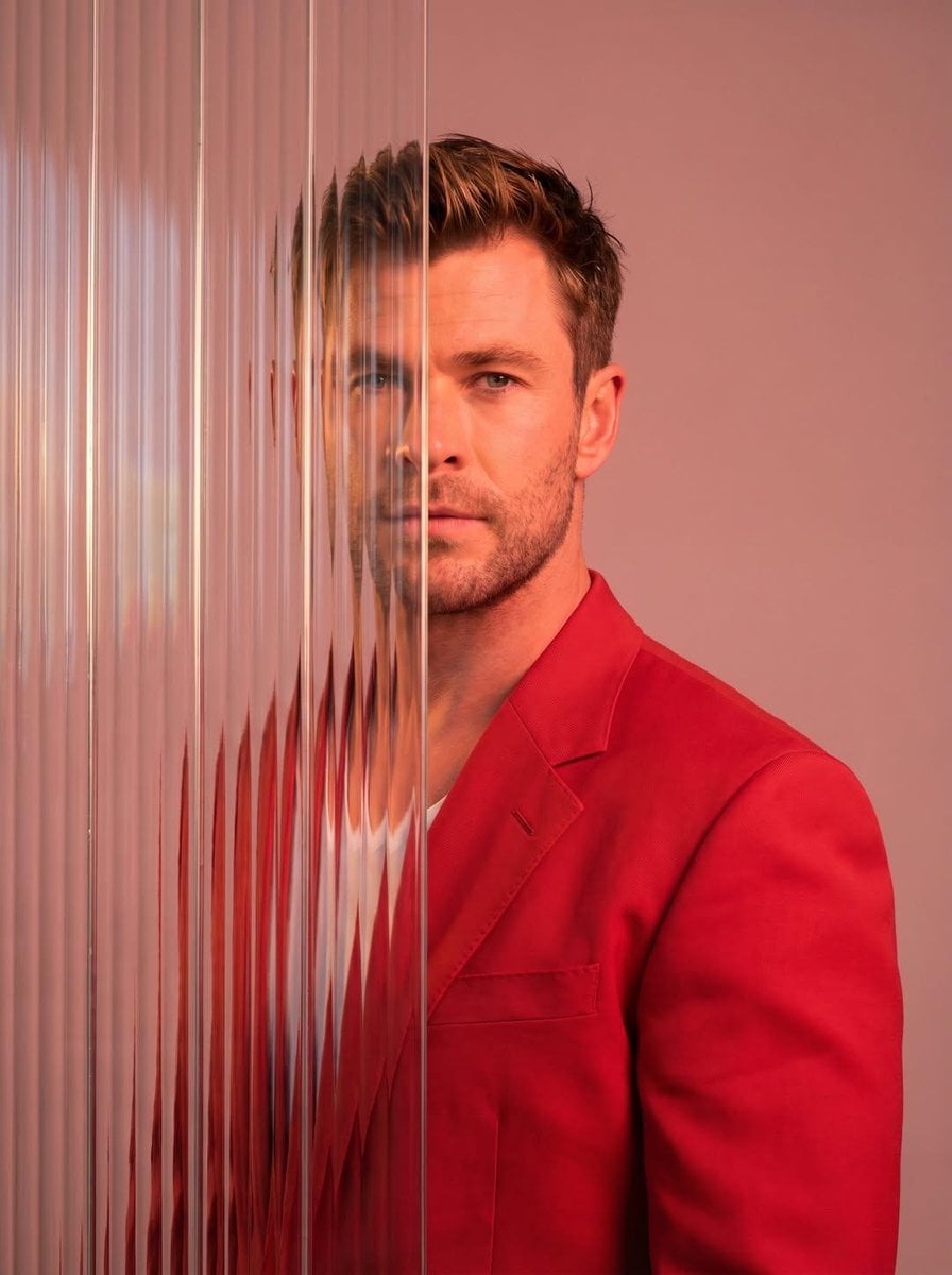 A striking editorial portrait photograph of a person wearing a red blaz…