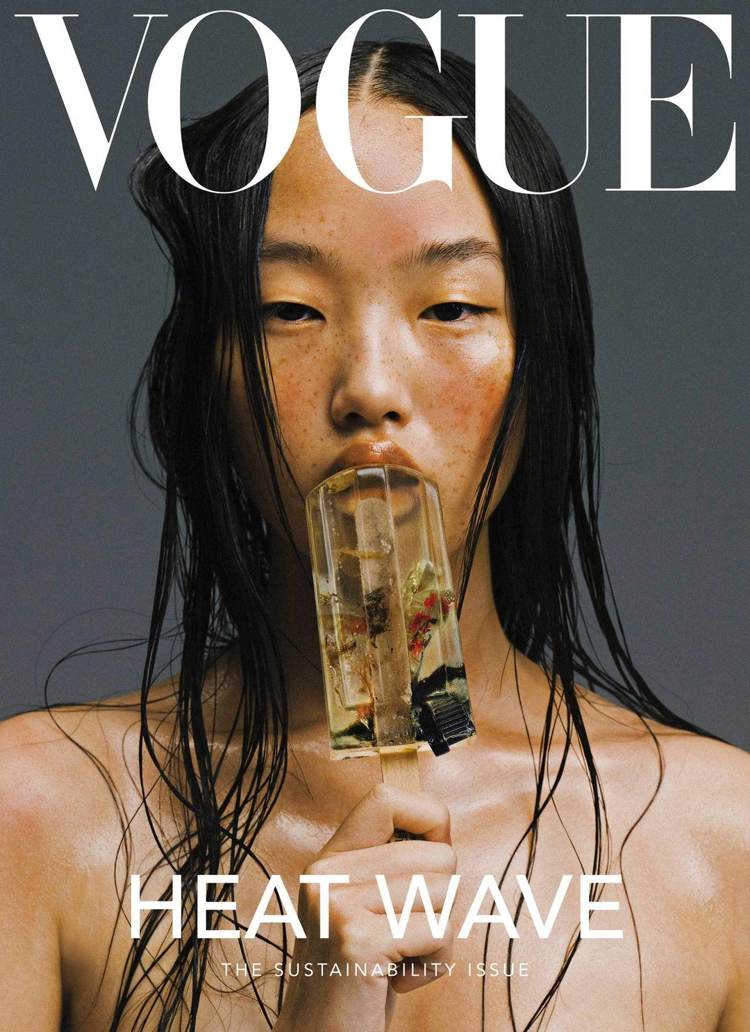 High-fashion editorial portrait of an East Asian model with wet, dark, …