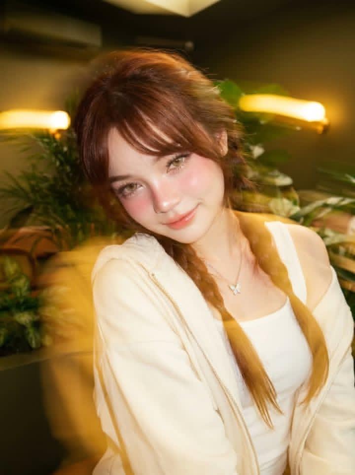 Ultra-realistic portrait of a beautiful young woman sitting in a cozy m…